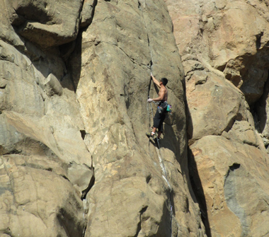 Rock climber on south facing cliff of North Table Mountain at 
		  Golden